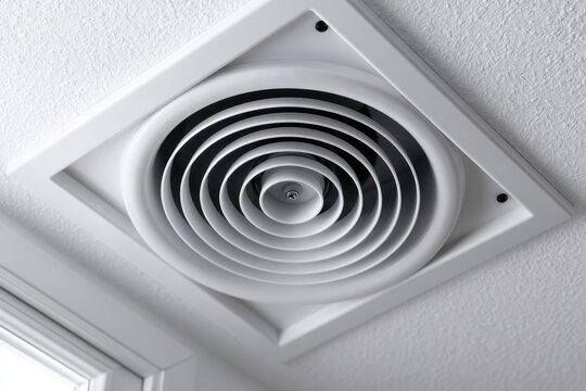 A circular white ceiling air diffuser vent installed on a textured wall. Represents residential climate control and.