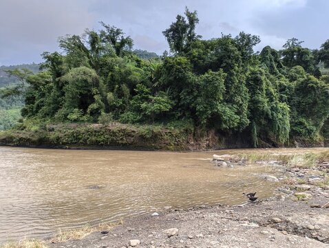 Sangu river flowing through lush green hills in Bandarban region of Bangladesh with dense tropical forest.