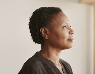 Obraz premium Thoughtful Mature 50s, 40s, Black Woman in Side Profile in a Minimal Interior