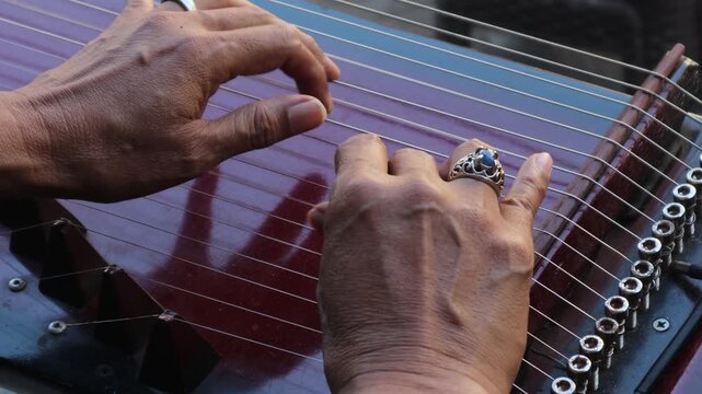Someone is playing the kecapi, a Sundanese musical instrument.