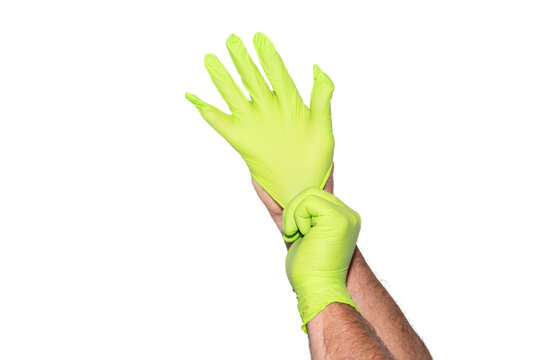 Hands putting on or donning bright green nitrile gloves in front of white background