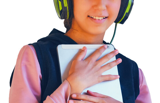 A bright close-up portrait of a happy young girl wearing stylish neon green and black headphones while holding a silver tablet. Isolated on a clean white background, this image perfectly represents mo
