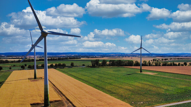 Windkraftanlagen &uuml;ber deutschen Feldern bei sonnigem Wetter