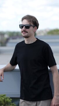 Man wearing black blank t-shirt with space for your logo or design. Mock up. Vertical 	