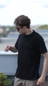 Man wearing black blank t-shirt with space for your logo or design. Mock up. Vertical 	