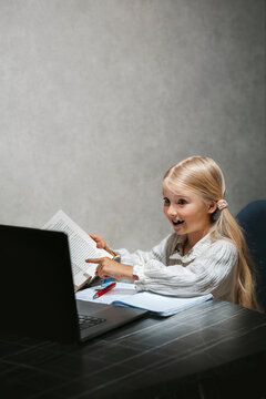 Elementary school child student studying online on laptop, curious girl reading and writing during interesting online lesson homeschooling digital learning education technology family lifestyle