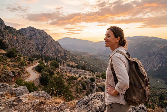 Woman hiker admiring ancient Greek ruins from a mountain viewpoint
