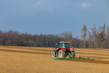 Obraz premium Farming tractor cultivating soil in Jihomoravsky kraj, Czechia