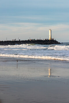Barra de Torres Lighthouse at the Mampituba River Entrance with Fishermen on the Jetties