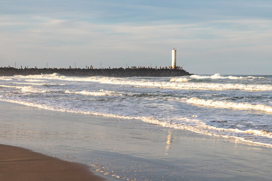 Barra de Torres Lighthouse at the Mampituba River Entrance with Fishermen on the Jetties