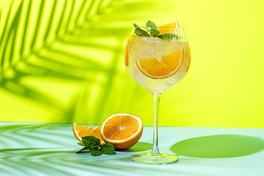 Refreshing drink with orange slices and mint placed on a bright background during daytime