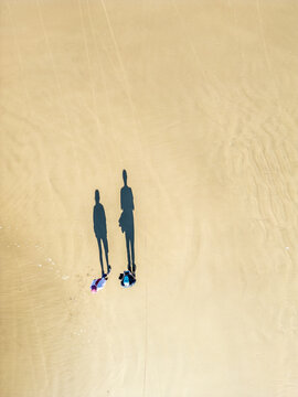 Top-Down Drone View of Couple Walking on Sand with Long Shadows