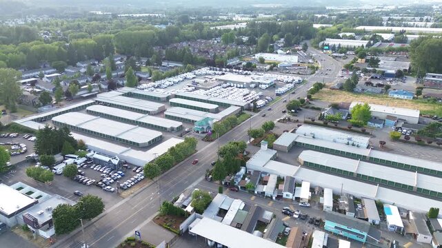Kent industrial grid State Route 167 separates massive storage complexes from surrounding residential pockets. Geometric white rooftops dominate the landscape, showcasing logistics layout in WA