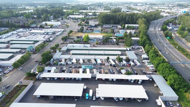 Storage unit sprawl Interstate 167 runs adjacent to expansive vehicle storage lots in Kent. Rows of metal shelters organized parking lanes illustrate heavy industrial density found throughout WA