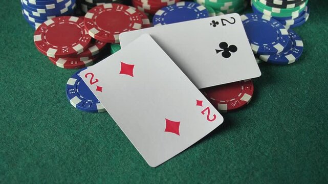 Playing cards placed on a green felt surface surrounded by colorful poker chips in a casino setting, showcasing a sequence of card reveals