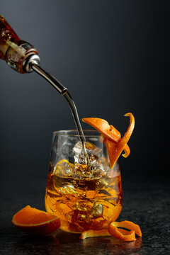 Old-fashioned cocktail in a fogged up glass on a black table.