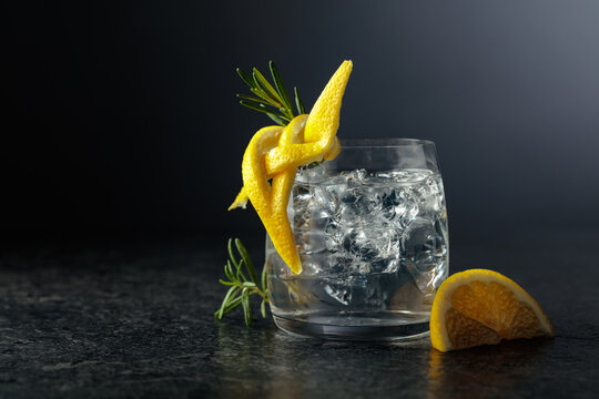 Gin and tonick cocktail in a fogged up glass on a black background.