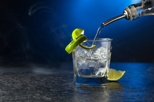 Vodka with lime and ice cubes in a fogged up glass.