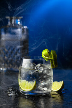 Vodka with lime and ice cubes in a fogged up glass.