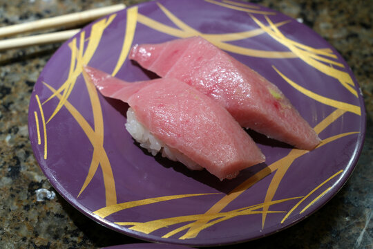 Fresh sushi on colorful plates in a Kaiten sushi restaurant in Japan