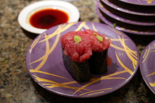 Fresh sushi on colorful plates in a Kaiten sushi restaurant in Japan
