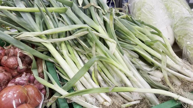 Close up of a pile of fresh raw green leeks or scallions at local grocery market