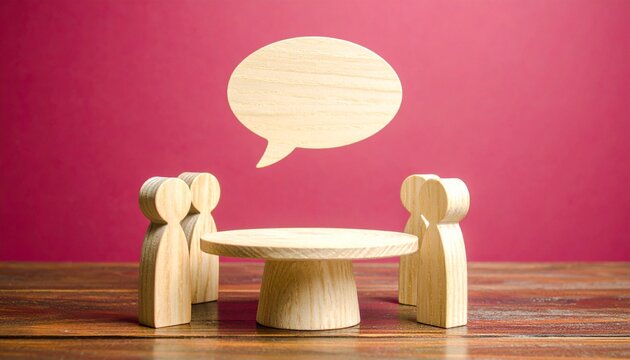 Wooden Peg Figures Gathered Around Round Table with Speech Bubble Communication Concept

