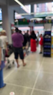 Blurred background of people shopping in supermarket, copy space