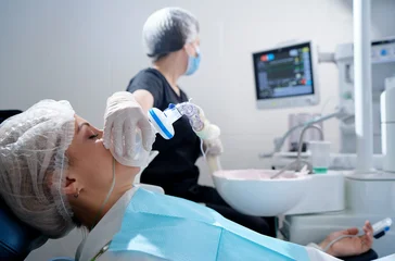 Doctor making anesthesia while female patient lying in dentist chair © Loginova