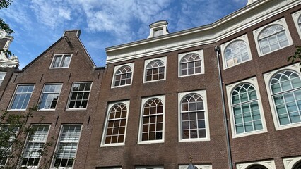 Obraz premium Grandes baies vitrées pour un maximum de lumière des maisons historiques au béguinage d'Amsterdam (Hollande)