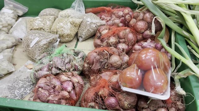 Assortment of fresh Asian grocery ingredients with shallots, tomatoes, and leeks at local market