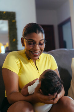 Mother smiling while holding sleeping newborn baby