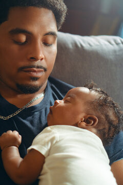 Father holding sleeping newborn baby creating special bond