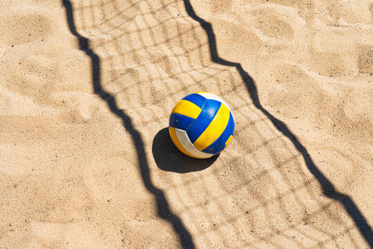 Beach volleyball court with a volleyball ball placed in the sand.