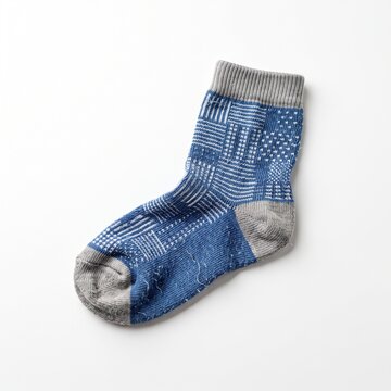 Blue and grey patterned sock with intricate geometric designs and ribbed cuff isolated on white background