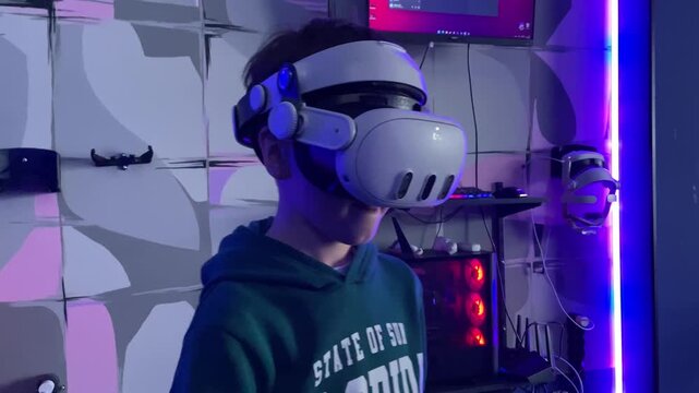 Boy wearing virtual reality headset playing immersive video game at home
