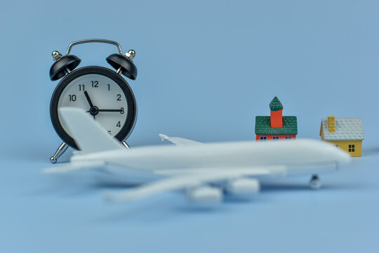 White airplane rests beside alarm clock