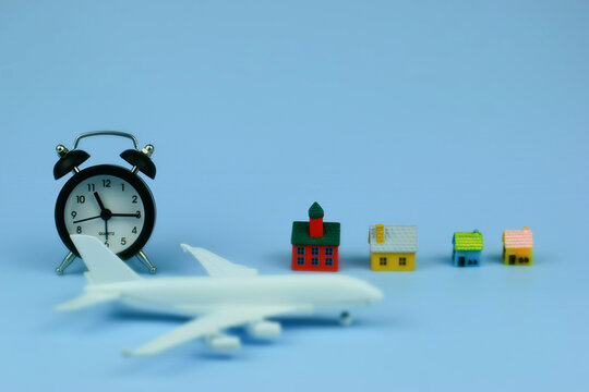 White airplane rests beside alarm clock