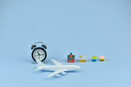 White airplane rests beside alarm clock