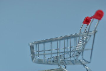 Mini shopping cart holds crumpled bills © Nazir