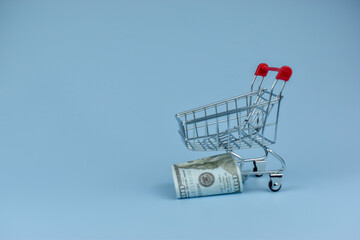 Mini shopping cart holds crumpled bills © Nazir