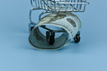 Mini shopping cart holds crumpled bills © Nazir