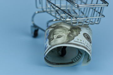 Mini shopping cart holds crumpled bills © Nazir