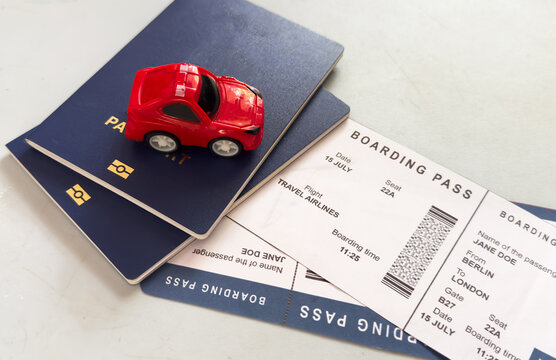 passport and boarding pass stacked on top of a toy car on a flat surface, possibly a desk or table, travel preparation, top-down perspective, blue and white, commercial, natural light, copy.