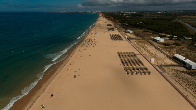 Aerial view of a tropical coastline at sunrise with clear turquoise water, white sand beach, and resorts 