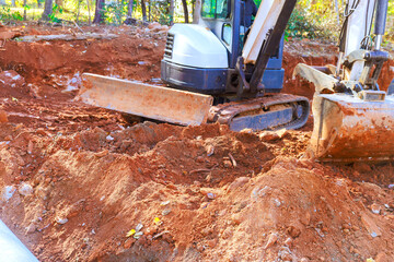 Fototapeta premium Construction equipment works on site to dig prepare ground for new building project