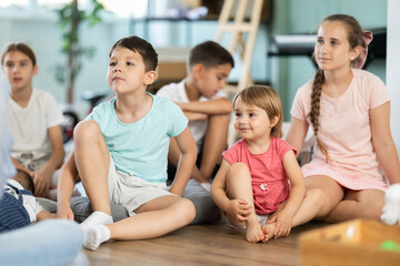 Obraz premium Boys and girls of different ages enthusiastically listen to teachers story about space, learning about world around them through fairy tales about travels of their favorite characters