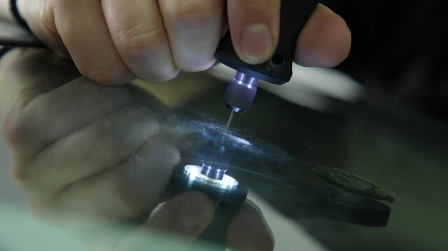 Auto glass repair drilling clearing glass dust from windshield chip 4K. Drilling into the center of a windshield bullseye chip to ensure proper polymer adhesive penetration