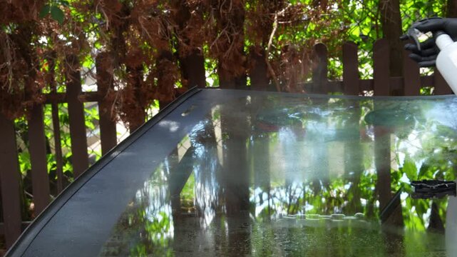 Mobile Windshield Installation Prep 4k video. Technician sprays cleaning solution on new auto glass. Spraying cleaning liquid onto new auto glass