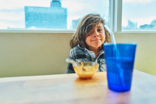 Boy smiling at the breakfast table with a city skyline behind